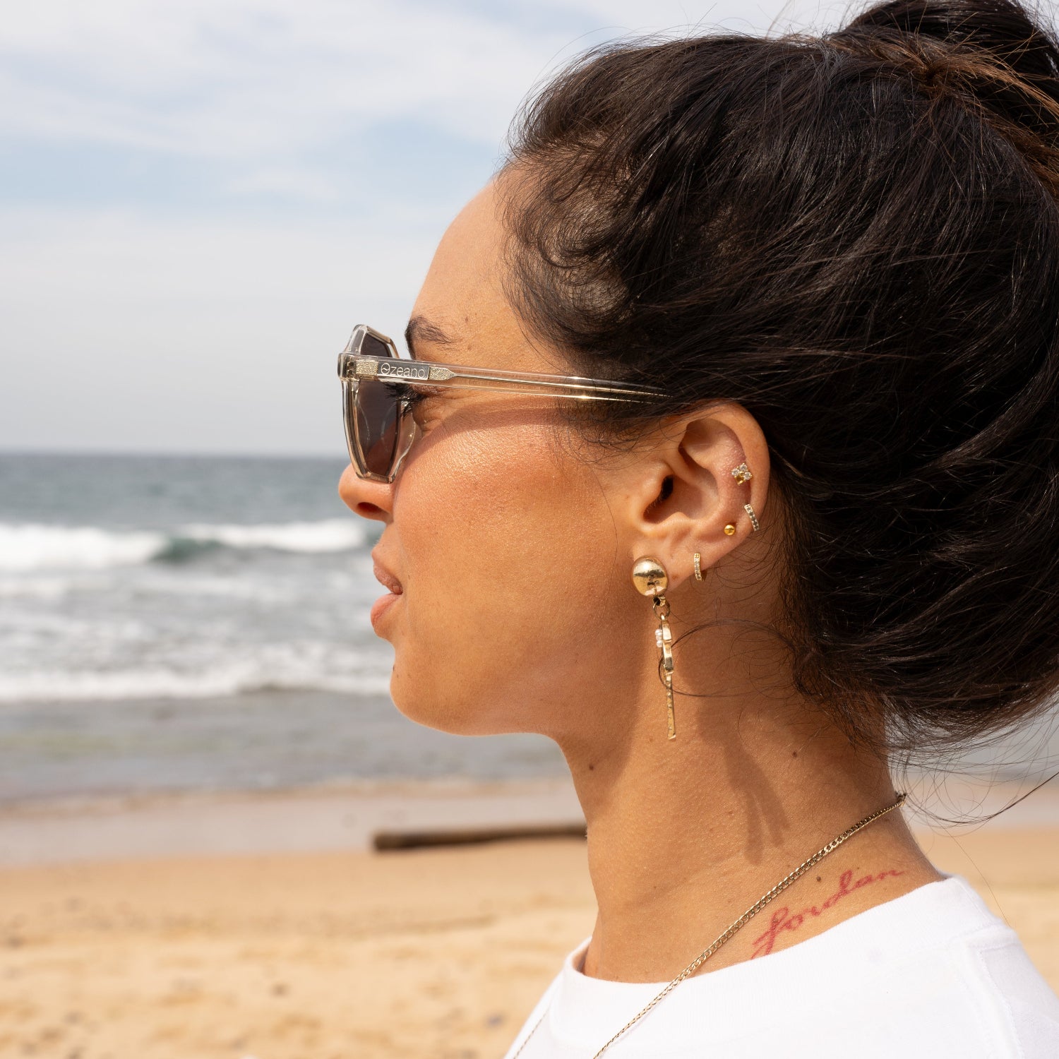 Female model wearing light transparent green eco sunglasses. Sustainable women polarised sunglasses. Coolum Turtle Polarised Sunglasses by Ozeano