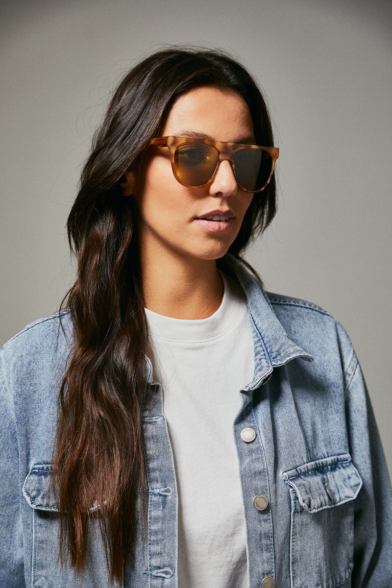 Female model wearing orange prescription sunglasses from Ozeano Vision