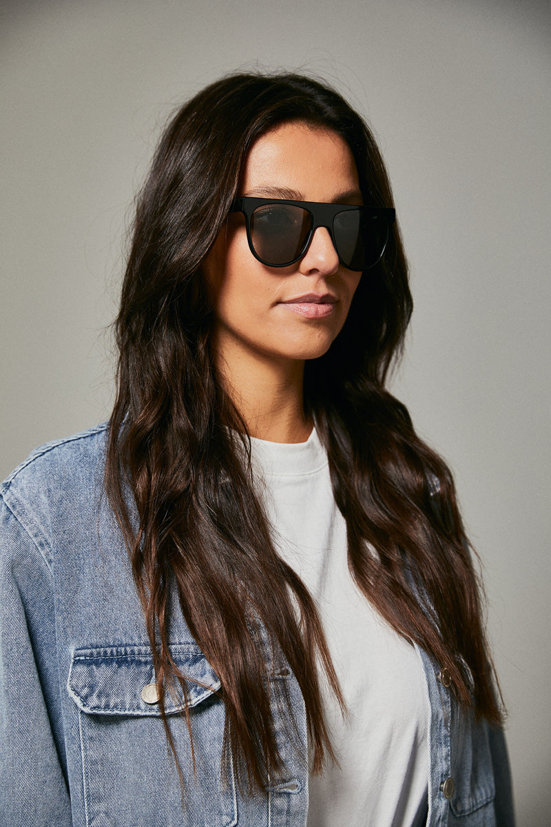 Female model wearing black prescription sunglasses from Ozeano Vision