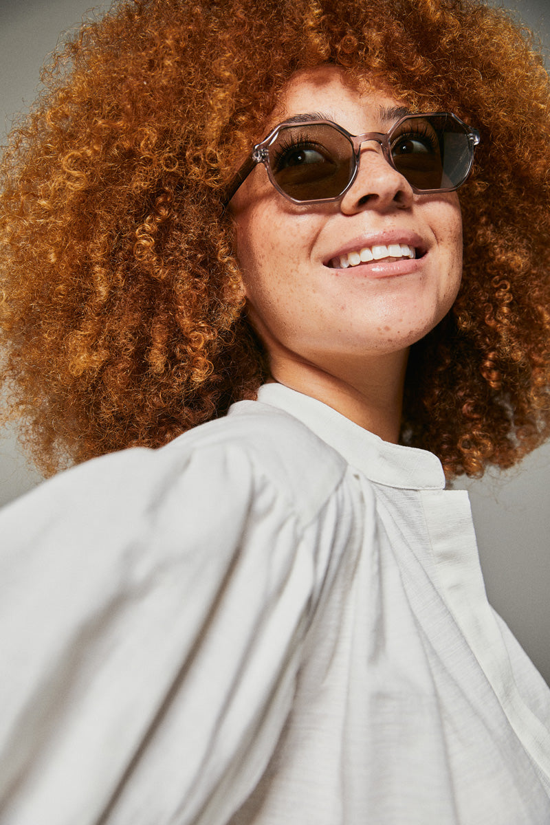 Female model wearing grey prescription sunglasses from Ozeano Vision