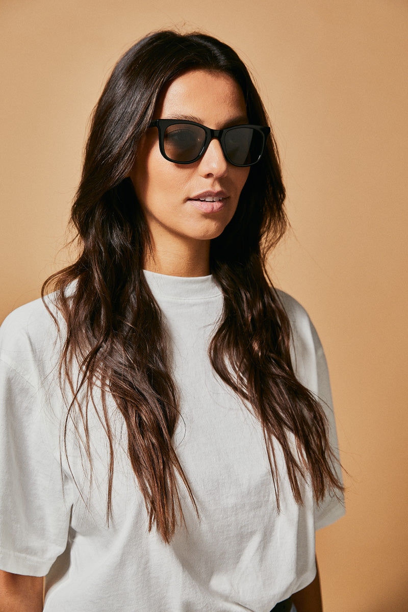 Female model wearing black prescription sunglasses from Ozeano Vision