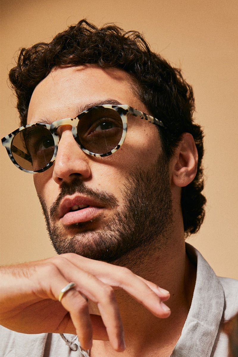 Male model wearing black and white prescription sunglasses