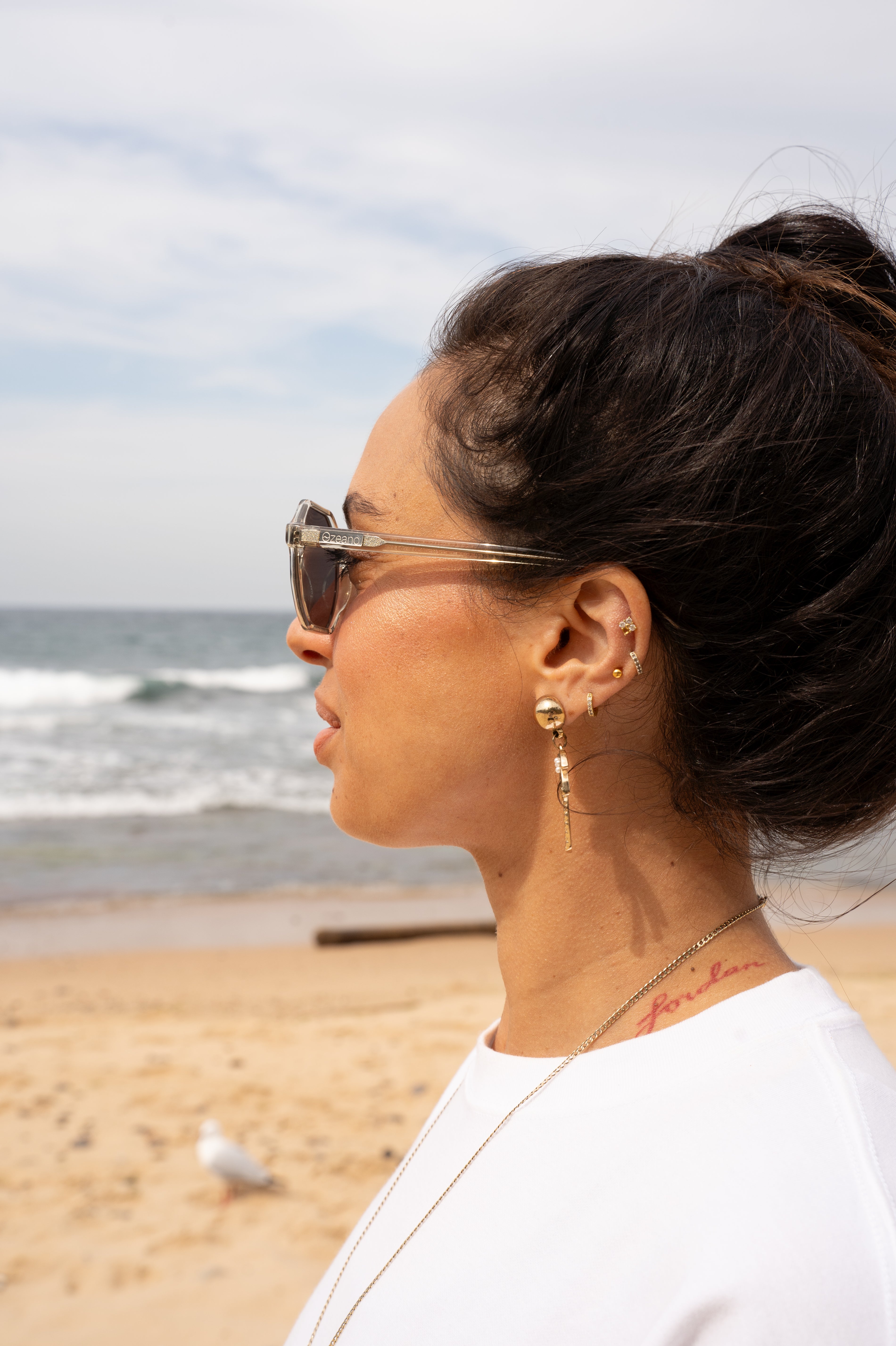 Female model wearing light transparent green eco sunglasses. Sustainable women polarised sunglasses. 