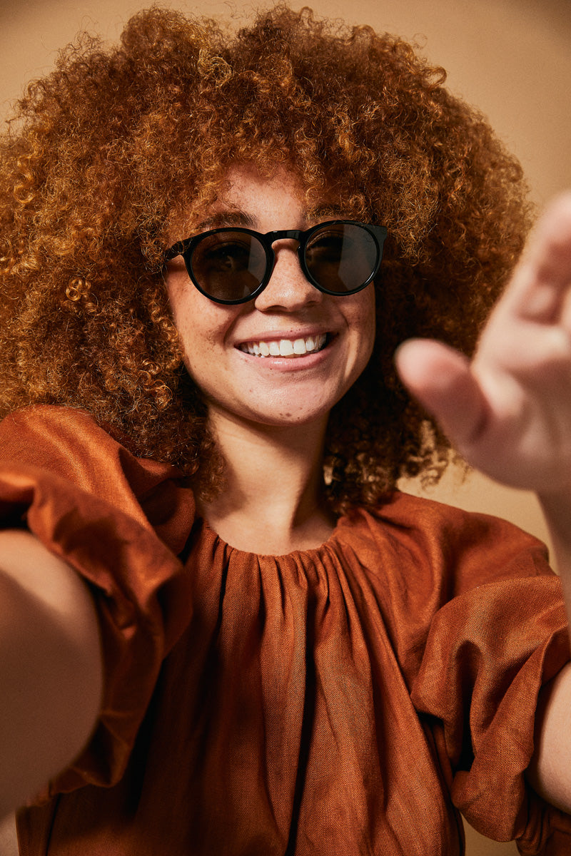 Female model wearing black prescription sunglasses